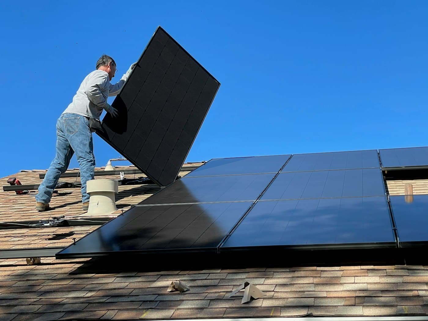 A technician fitting a solar module onto a sloped roof