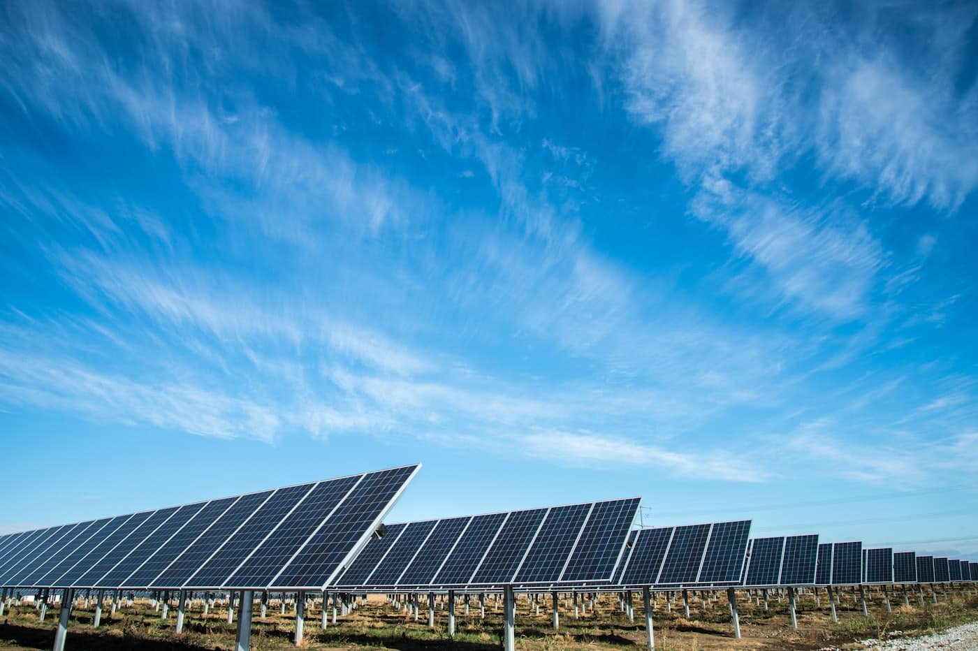 Solar panels angled towards a bright blue sky